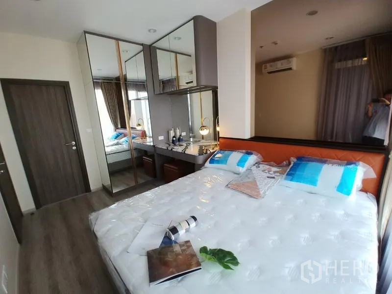 公寓 出租在Huai Khwang, Bangkok - 明亮卧室，配大床、镜面衣柜、梳妆台与大窗。