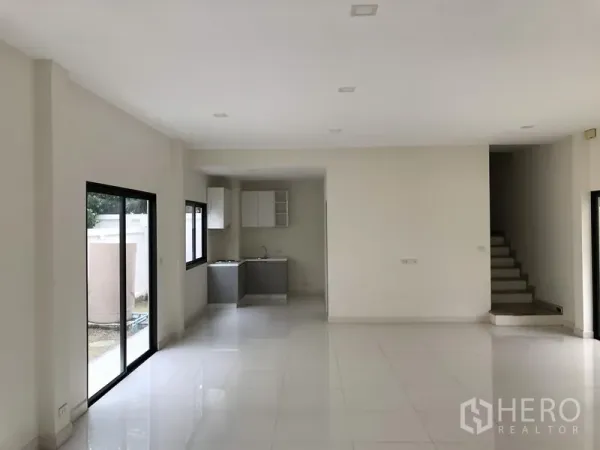 Townhouse for rent or sale in Saphan Sung, Bangkok - Spacious living–dining zone leading to a compact built-in kitchen and backyard access.