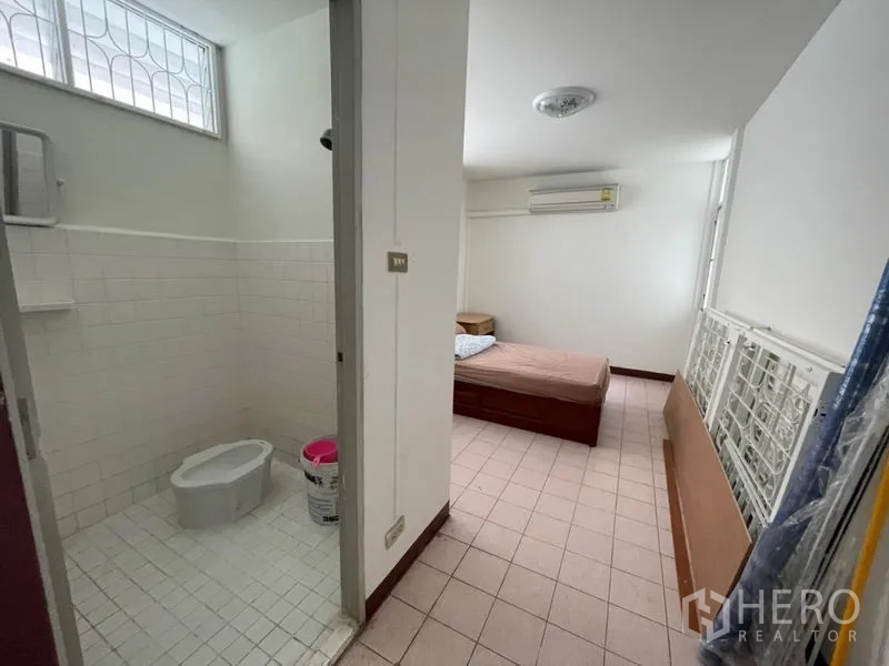 Detached House for rent in Khlong Toei, Bangkok - Adjoining bathroom with tiled walls and a squat toilet.