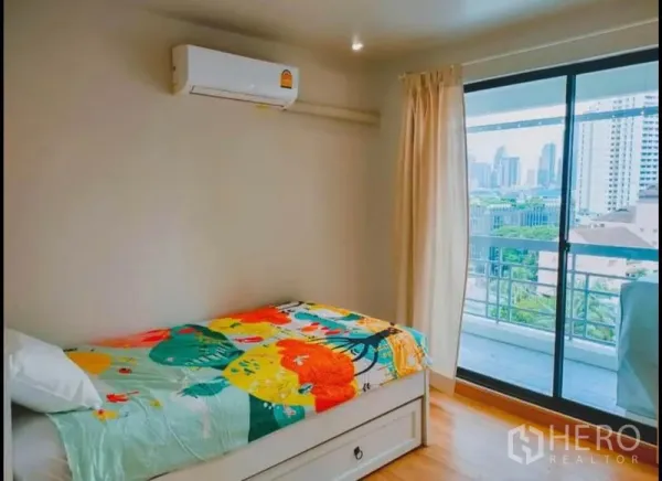 公寓 出售在Watthana, Bangkok - 明亮单人房，推拉门通向可观城市景观的阳台。