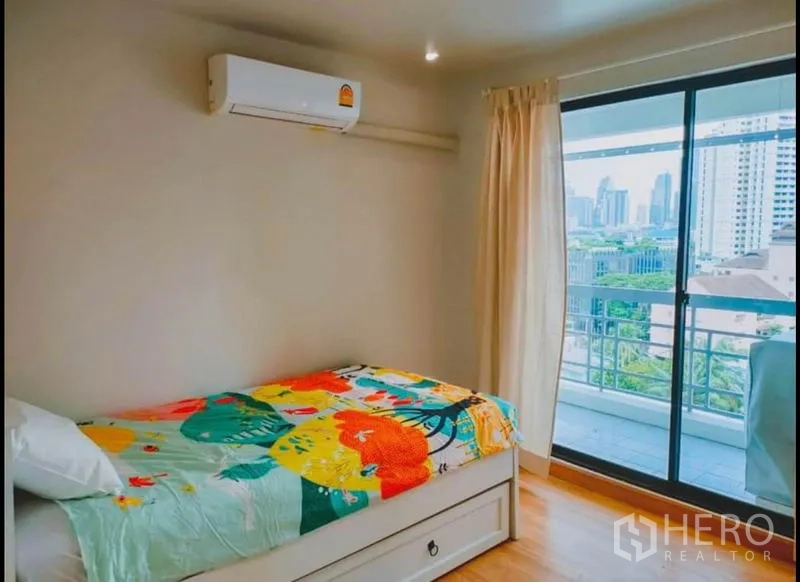 公寓 出售在Watthana, Bangkok - 明亮单人房，推拉门通向可观城市景观的阳台。