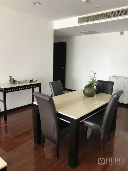 Condominium for rent in Khlong Toei, Bangkok - Four-seat dining table beside a console table in a minimalist interior.