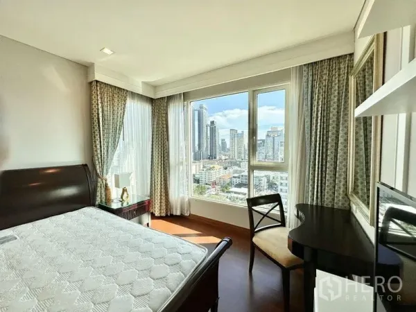 Condominium for rent in Watthana, Bangkok - Corner bedroom with large windows, desk, and Bangkok skyline view.