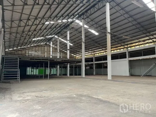 Warehouse for rent in Nong Khaem, Bangkok - Spacious warehouse interior with high steel truss roof, skylights and mezzanine platforms.