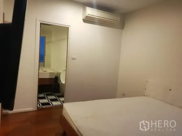 公寓 出租在Watthana, Bangkok - 次卧配空调，通往套内卫浴，装饰简洁。