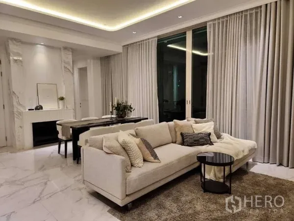 คอนโด ขายในWatthana, Bangkok - ห้องนั่งเล่นและรับประทานอาหารแบบโอเพนแปลน พื้นหินอ่อน ไฟซ่อน โซฟาสีครีม และม่านสูงทั้งผืน ที่ Royce Private Residences