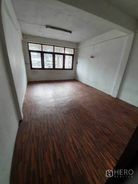 Shophouse for rent in Watthana, Bangkok - Bright room with large windows and wooden floor, ideal for office or studio.