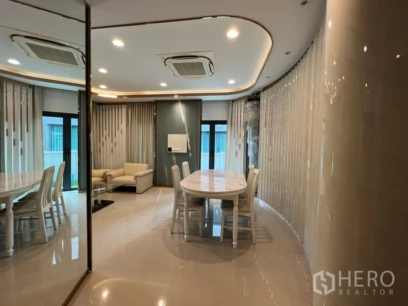 Detached House for rent in Saphan Sung, Bangkok - Mirror-lined dining and living area with chandelier and ceiling cassette AC.
