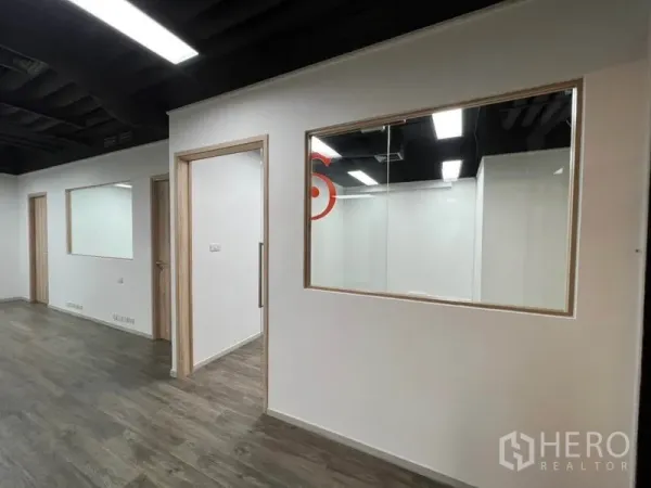 Office Space for rent in Khlong Toei, Bangkok - White partition walls with interior windows and LEDs in the ceiling.