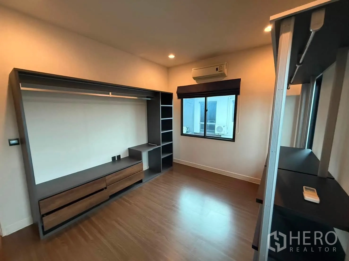 Detached House for rent in Bang Kapi, Bangkok - Custom wardrobe wall with drawers beneath and a window air conditioner.