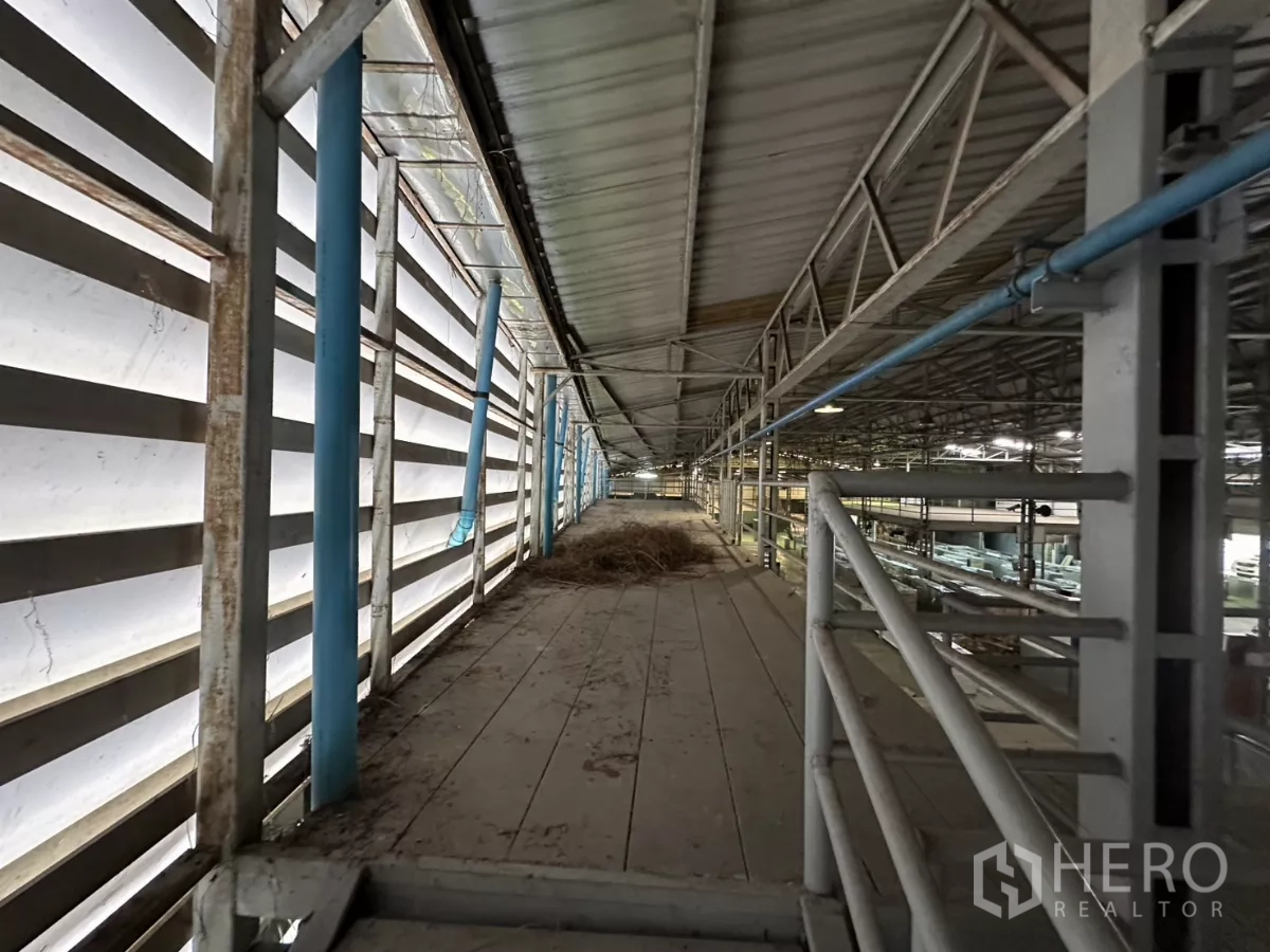 Warehouse for rent in Yan Nawa, Bangkok - Side catwalk along a louvered facade with blue service pipes.