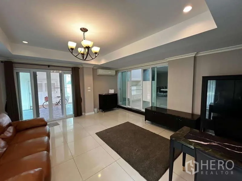 独立式住宅 出租在Prawet, Bangkok - 客厅面向推拉玻璃门，连接有顶露台。