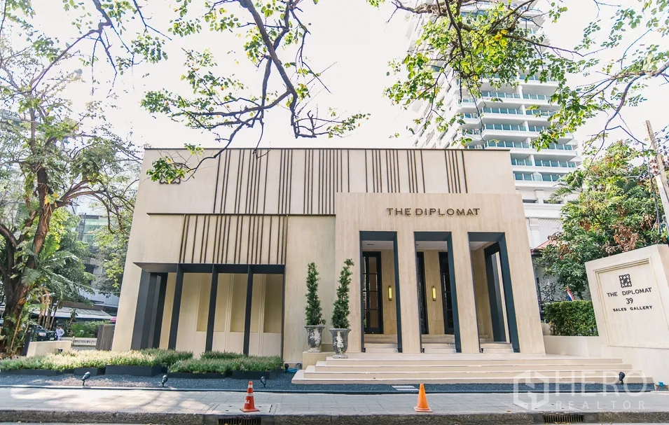 公寓 出租或出售在Watthana, Bangkok - 公寓入口外观，现代建筑与绿化前庭。