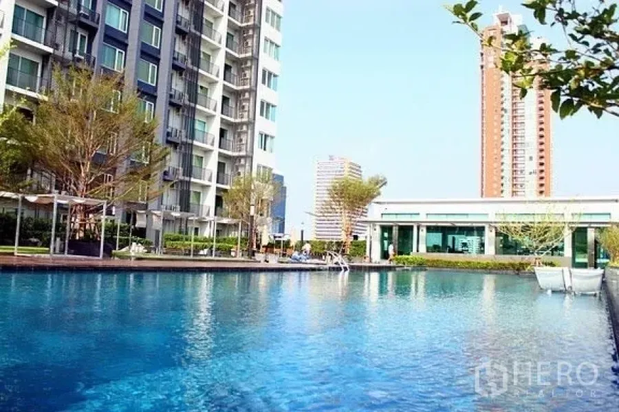 Condominium for rent in Khlong Toei, Bangkok - Outdoor condominium swimming pool with sundeck and modern high-rise buildings in Khlong Toei, Bangkok.