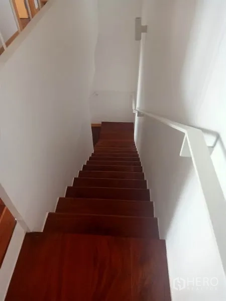 公寓 出租在Watthana, Bangkok - 室内木质楼梯配白色扶手，多层户型。