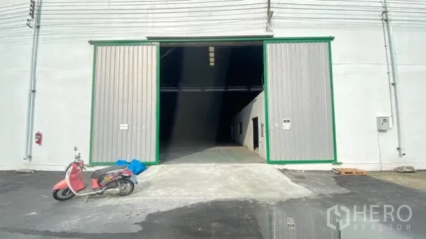 货栈 出租在Samut Prakan - 仓库前部的超宽金属推拉门与进出坡道。