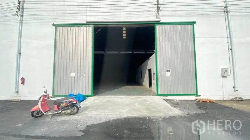 货栈 出租在Samut Prakan - 仓库前部的超宽金属推拉门与进出坡道。