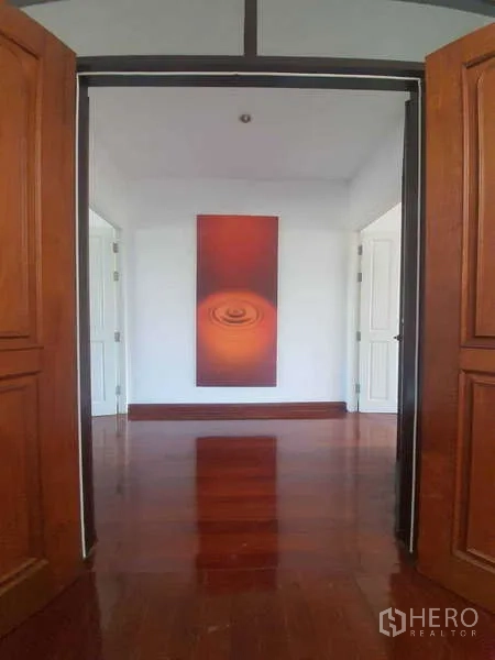 Townhouse for rent in Khlong Toei, Bangkok - Double wooden doors opening to an upper landing with glossy wood flooring.