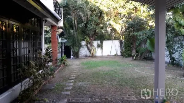Detached House for rent in Yan Nawa, Bangkok - Large private lawn garden bordered by mature trees and a perimeter wall next to the house.