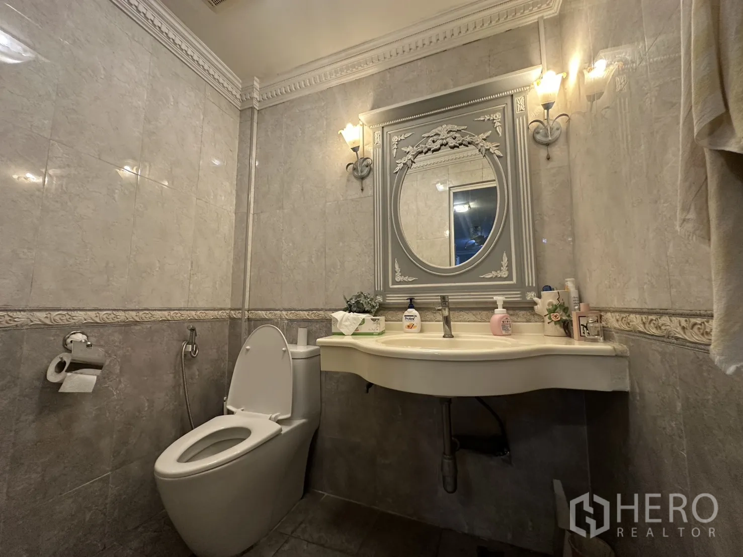 ตึกแถว for sale in Watthana, Bangkok - ห้องน้ำปูกระเบื้องสไตล์คลาสสิกพร้อมโคมไฟผนัง กระจกกรอบลาย และโถสุขภัณฑ์.