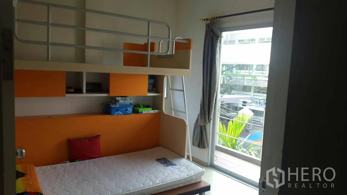 Townhouse for rent in Suan Luang, Bangkok - Children’s bedroom with loft bunk, orange storage and access to a small balcony.