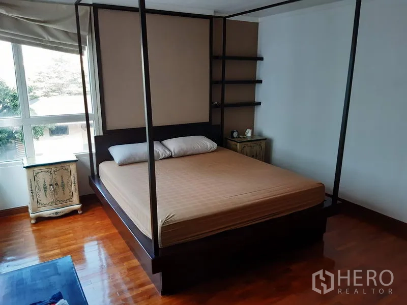 公寓 出售在Watthana, Bangkok - 主卧配四柱床、木地板与大窗，采光充足。