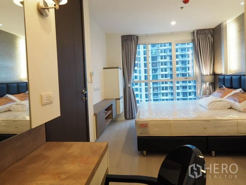 公寓 出租在Sathon, Bangkok - 从书桌望向大窗与内置电视柜的主卧。