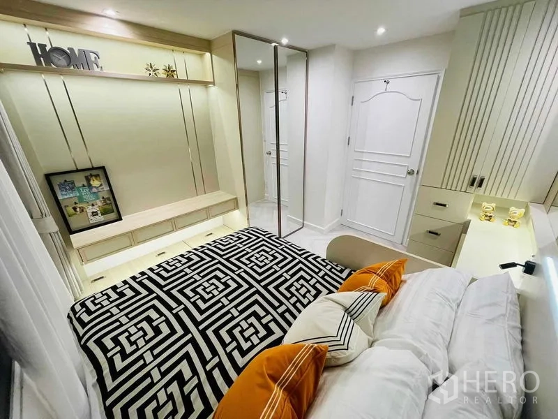 公寓 出售在Yan Nawa, Bangkok - 卧室配橙色抱枕、床侧梳妆台与精致柜体。