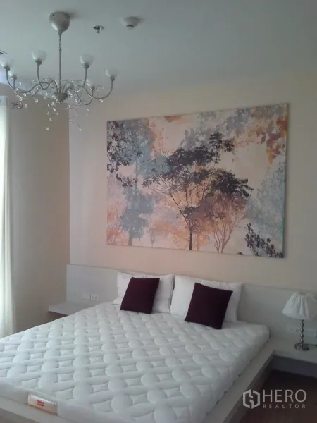 Condominium for rent or sale in Watthana, Bangkok - Cozy bedroom with a king bed, chandelier and large art above the headboard.