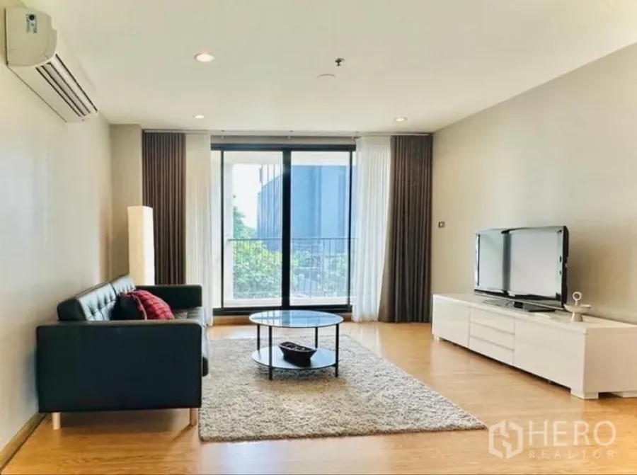 คอนโด ให้เช่าในWatthana, Bangkok - ห้องนั่งเล่นกว้าง โซฟา ชั้นวางทีวี และประตูกระจกบานเลื่อนออกระเบียง
