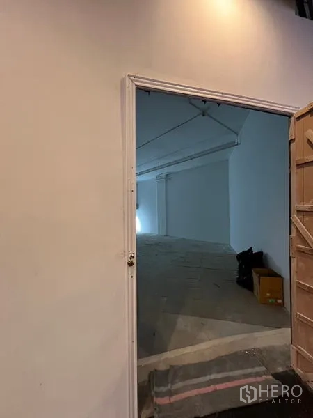 Retail Space for rent - Entrance doorway leading into a blank retail space with uniform ceiling lights and room for signage.