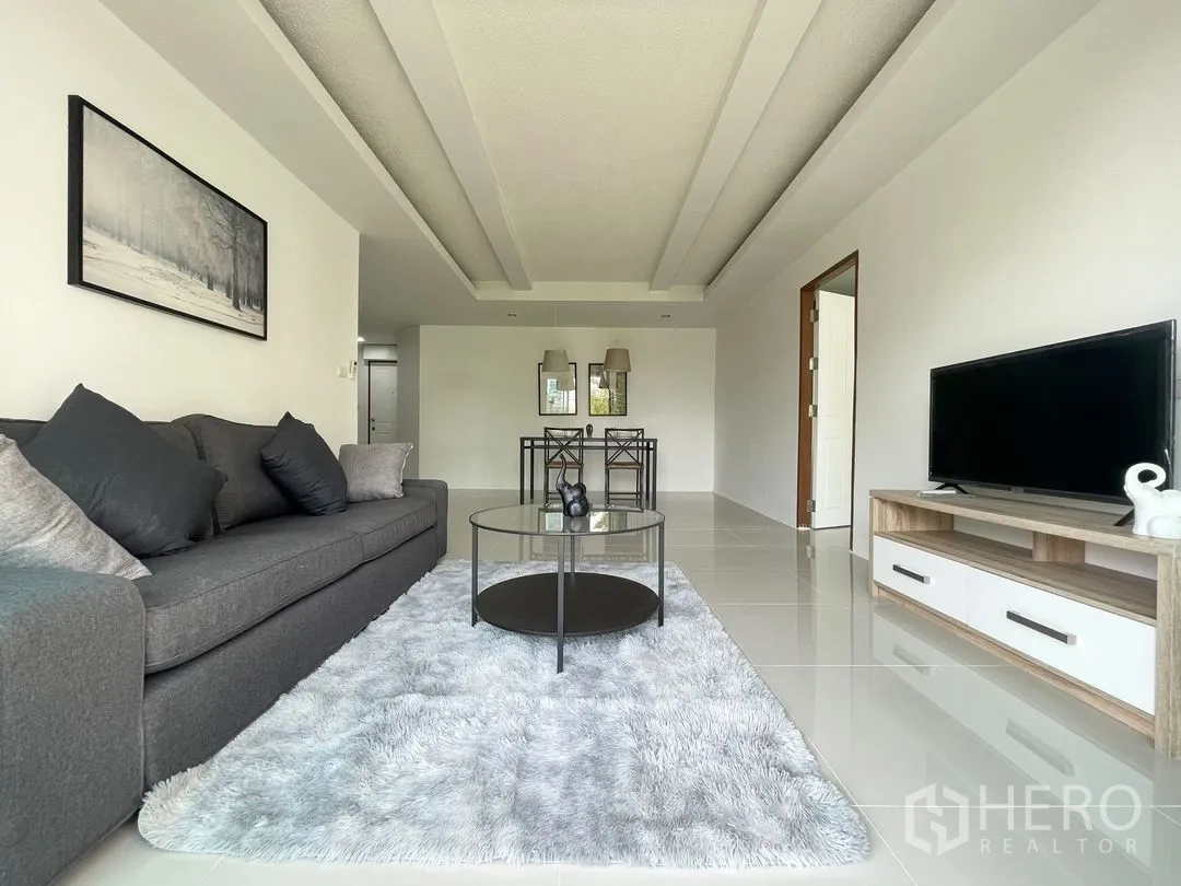 คอนโด for rent in Khlong Toei, Bangkok - ภาพกว้างของห้องนั่งเล่น เห็นโซฟา ชั้นวางทีวี และชุดทานอาหารด้านหลัง