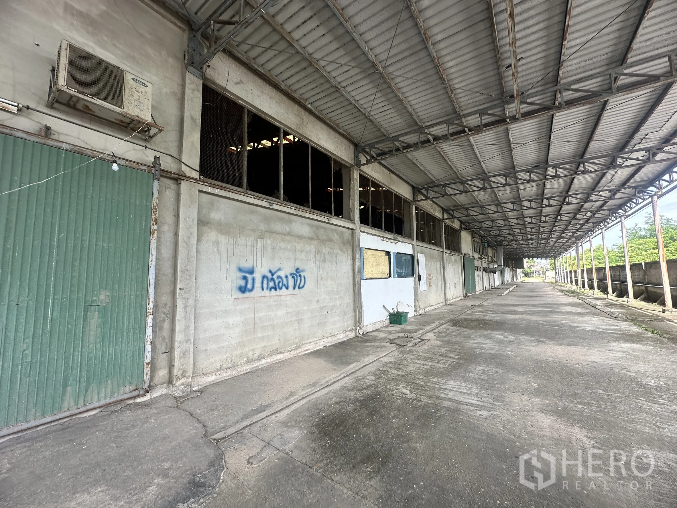Factory for sale in Sai Noi, Nonthaburi - Extended covered loading bay running beside the warehouse.