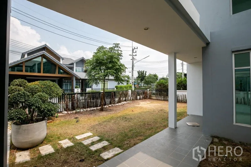 Detached House for rent or sale in Lam Luk Ka, Pathum Thani - Covered patio overlooking a small front garden and fence line.
