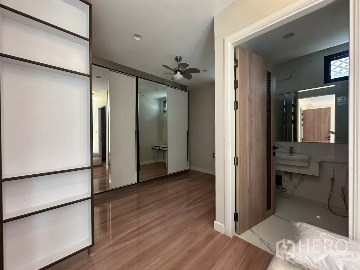 Townhouse for rent in Watthana, Bangkok - Bedroom with built-in storage and a door leading to an ensuite bathroom.