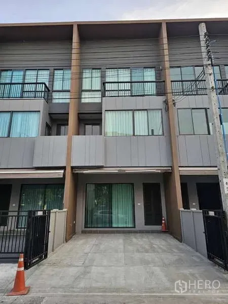 联排别墅 出租在Suan Luang, Bangkok - 联排别墅外观，带私家停车位、玻璃入户门与阳台。