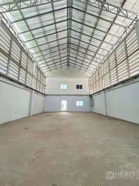 货栈 出售在Lat Lum Kaeo, Pathum Thani - 高挑仓库内部，钢桁架屋顶，侧向百叶通风，混凝土地面。
