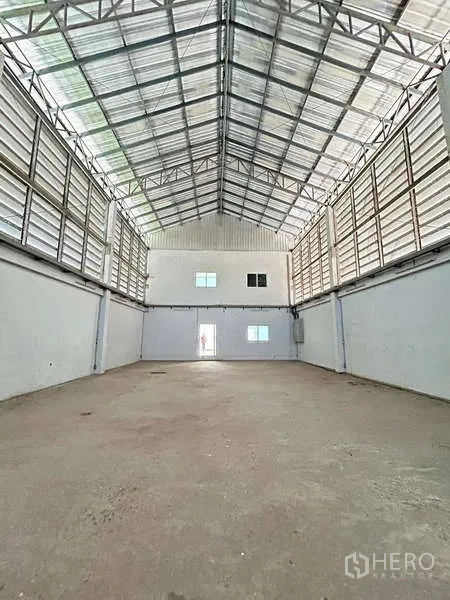 货栈 出售在Lat Lum Kaeo, Pathum Thani - 高挑仓库内部，钢桁架屋顶，侧向百叶通风，混凝土地面。