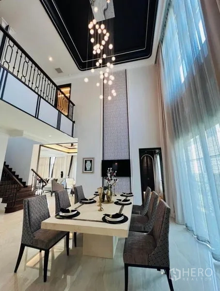 บ้าน ให้เช่าหรือขายในWatthana, Bangkok - ห้องอาหารเพดานสูงสองชั้น โต๊ะยาว และโคมไฟแขวนดีไซน์