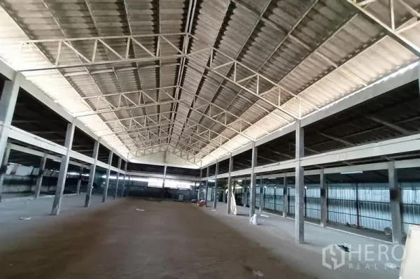 Warehouse for rent in Saphan Sung, Bangkok - Expansive warehouse interior with high gable roof, steel trusses, and open floor space.