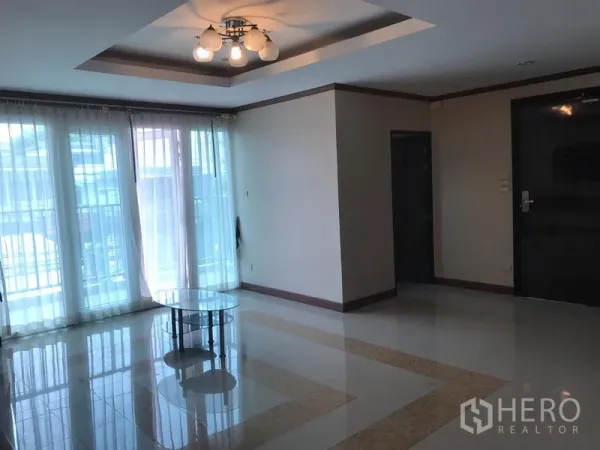 房间 出租在Watthana, Bangkok - 明亮起居区，吊灯与通高落地阳台门，配纱帘。