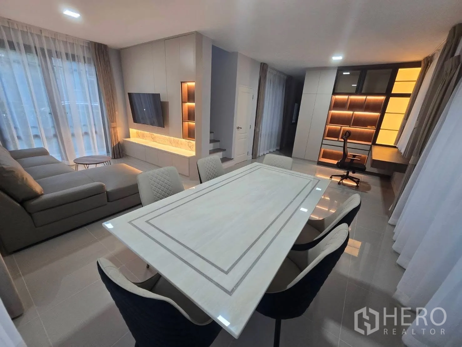 บ้านแฝด for rent in Bang Phli, Samut Prakan - โซนรับแขกและทานอาหารแบบโอเพ่นสเปซ โซฟาเข้ามุม ผนังทีวี และโต๊ะอาหาร 6 ที่นั่ง.