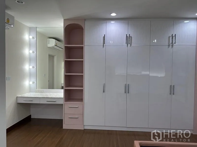 Detached House for sale in Saphan Sung, Bangkok - Wardrobe wall with makeup vanity and illuminated mirror in the bedroom.