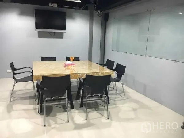 联排别墅 出售在Wang Thonglang, Bangkok - 会议室，大理石桌、黑色椅子、壁挂电视与玻璃白板