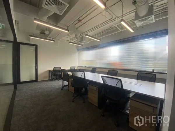 办公室 for rent in Bang Rak, Bangkok - 沿整面窗户布置的办公区，配长桌、网椅和线性吊灯。