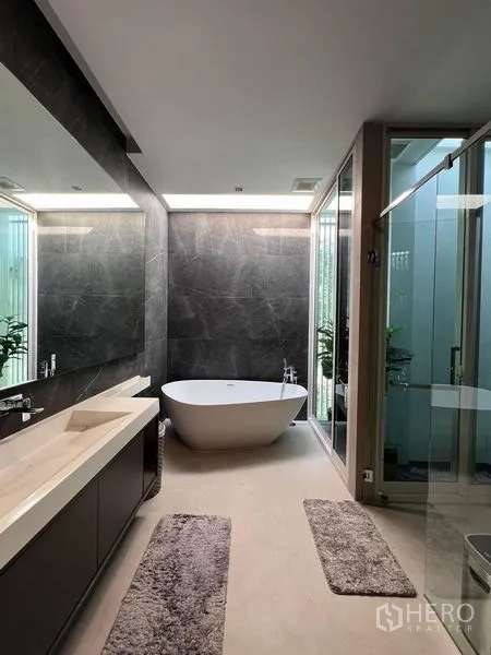 Detached House for sale in Samut Prakan - Luxury bathroom featuring a freestanding bathtub, double vanity, and glass shower.