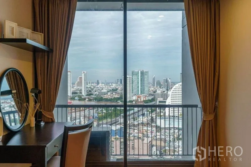 公寓 出租或出售在Bang Rak, Bangkok - 卧室或梳妆书写角，书桌面向阳台窗，视野开阔。