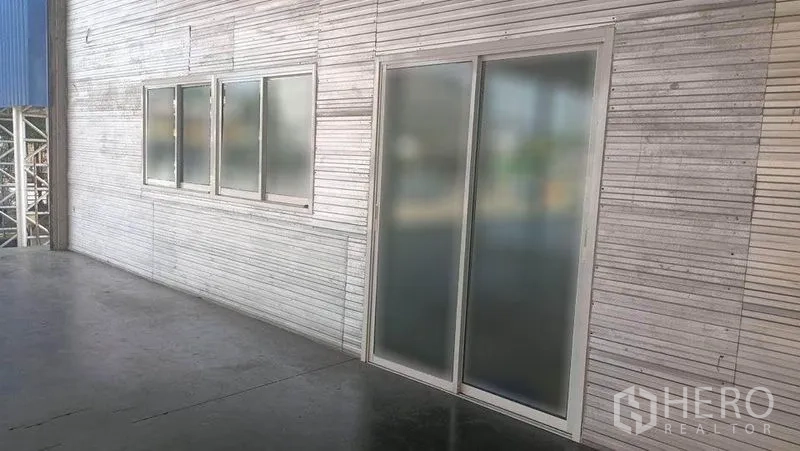 คลังสินค้า ให้เช่าในBang Phli, Samut Prakan - ผนังภายนอกโกดังพร้อมประตูกระจกฝ้าและหน้าต่างเรียงตามชานโหลด