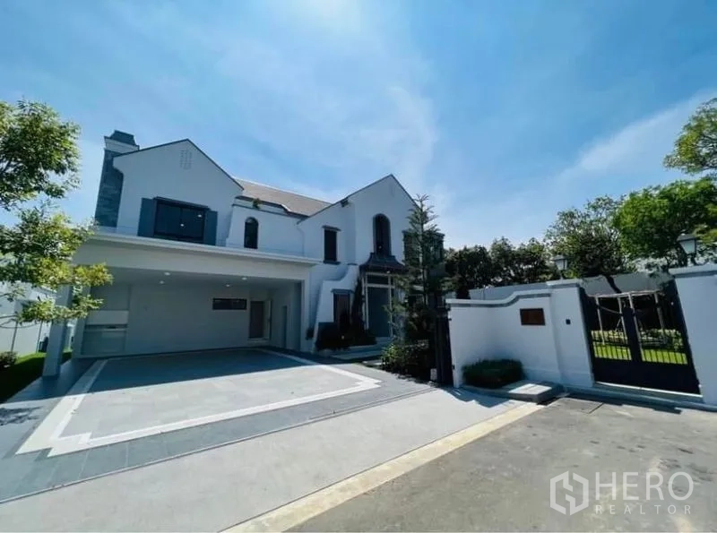 Detached House for rent or sale in Saphan Sung, Bangkok - Gated entrance with wide driveway and covered multi-car carport in front of the house.