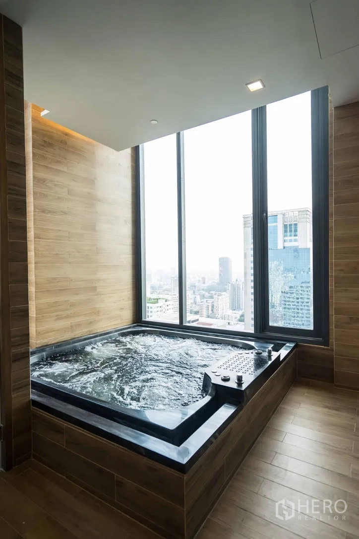 公寓 出租在Watthana, Bangkok - 室内按摩池，靠近通高窗户，可俯瞰城市。